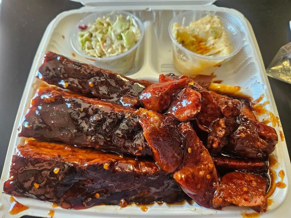 An overhead tray of CJ's glossy barbecue ribs and hot links